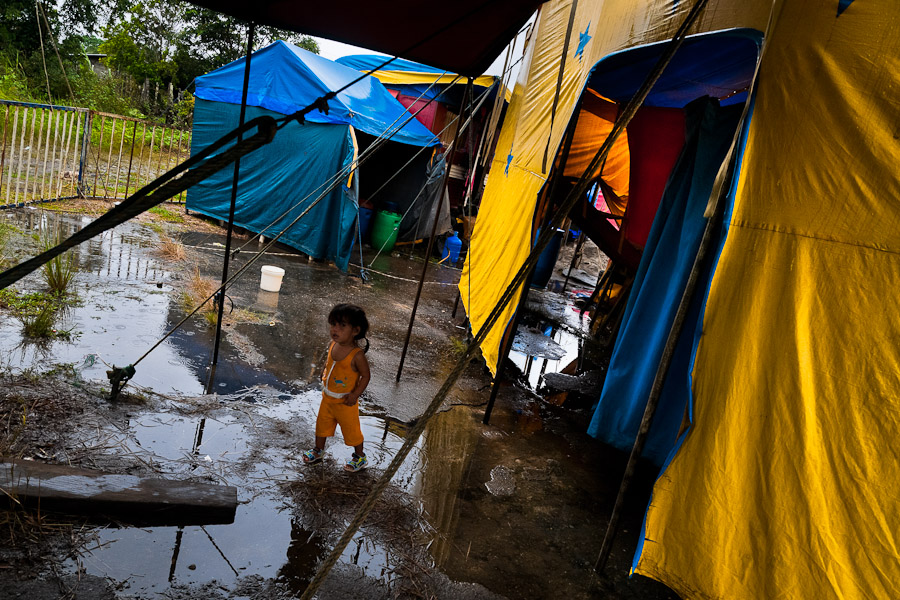 A little Colombian girl walks through puddle at the Circo Anny, a family run circus wandering the Amazon region of Ecuador,