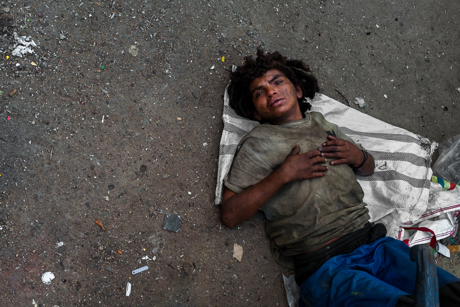 A Colombian drug addict, intoxicated with “basuco” (semi-refined cocaine paste), lies on the ground on the street of the El Bronx neighborhood in Medellín, Colombia.