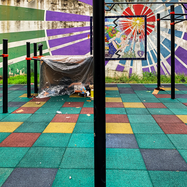 An Argentinian man sleeps in an improvised plastic shelter built between the gymnastics bars on a playground in downtown Buenos Aires, Argentina.